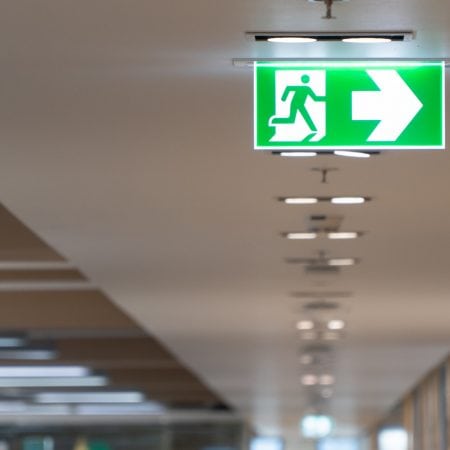 Fire Exit Strategy A green fire exit sign installed on a ceiling