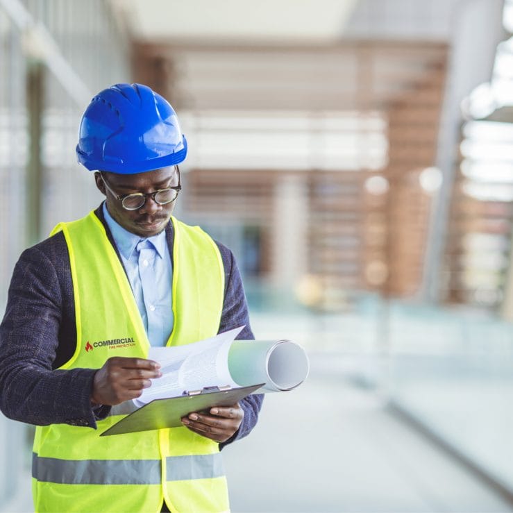 A contractor looking at papers for a Fire Exit Strategy