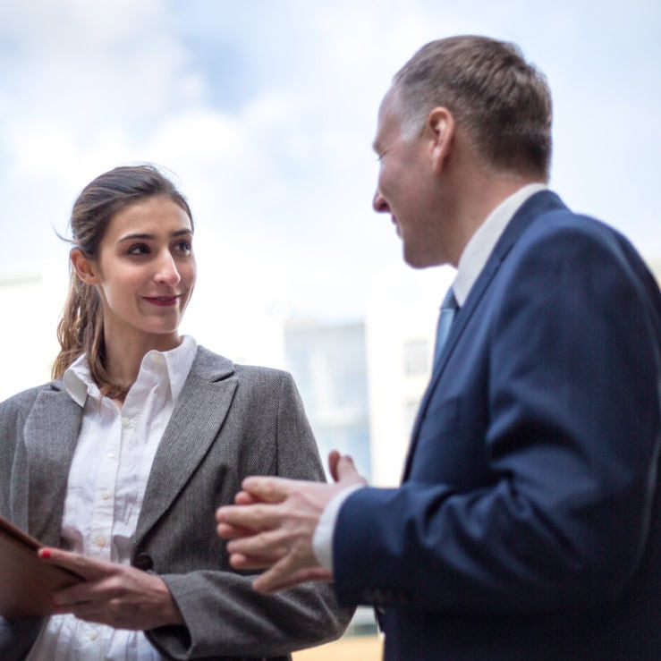 Two people in professional clothing speaking